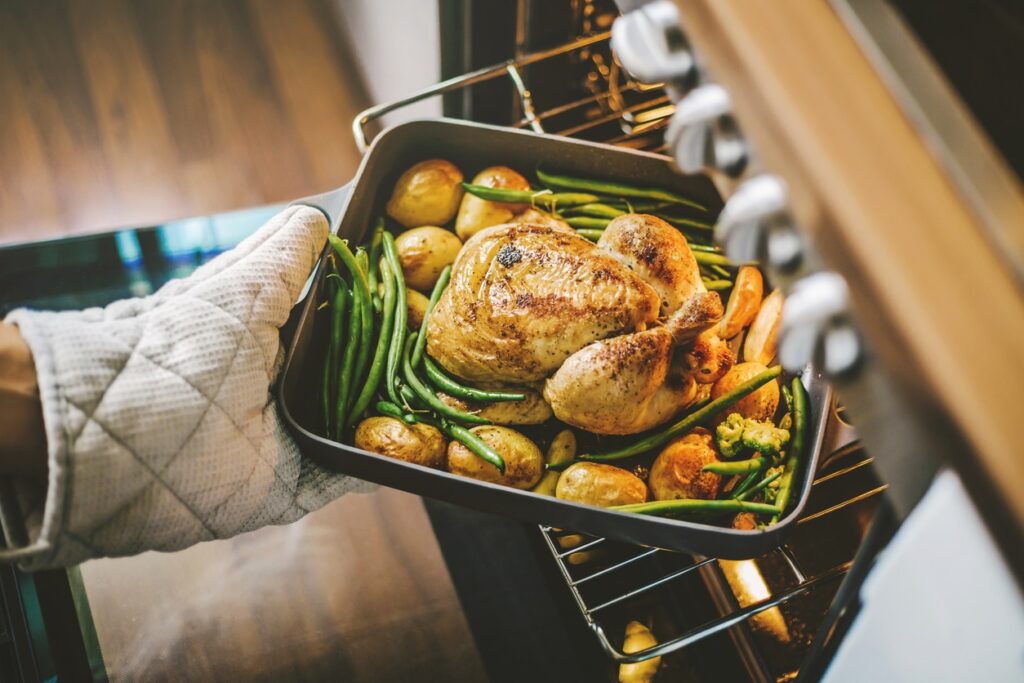taking chicken from the oven